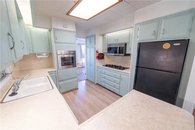 a kitchen with granite countertop a refrigerator and a stove top oven