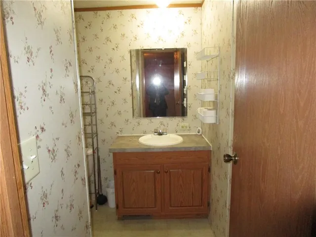 a bathroom with a granite countertop sink and mirror