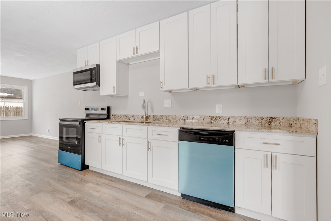 1893 Benjamin Road Madison, OH 44057 - Photo 4 of 23 Kitchen featuring appliances with stainless steel finishes, white cabinets, and light wood-style floors