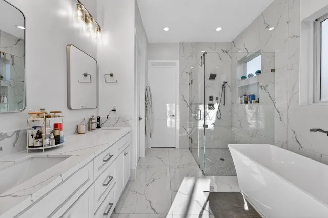 a bathroom with a double vanity sink toilet mirror bathtub and shower