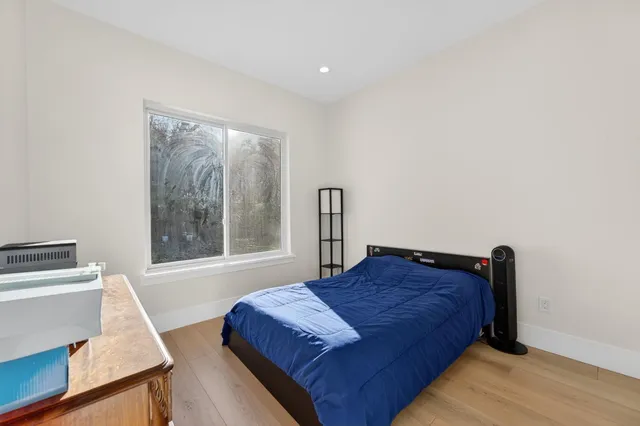 a bedroom with a bed window with a mirror