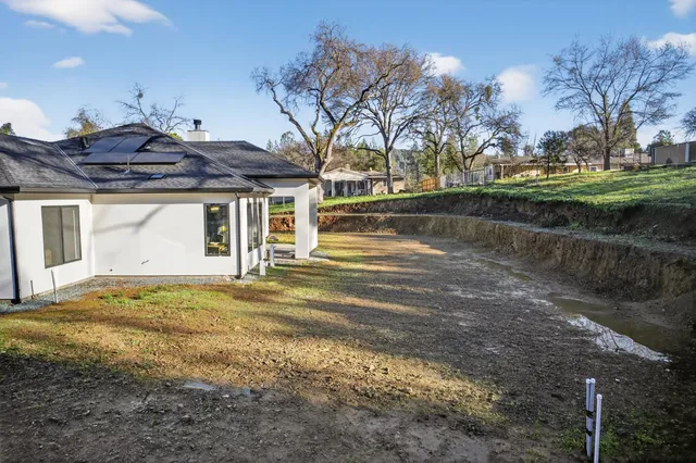 a view of a house with backyard and sitting area