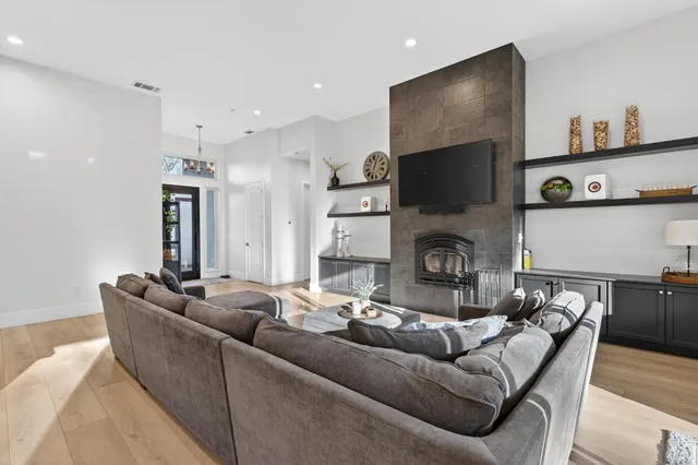a living room with furniture a fireplace and a flat screen tv