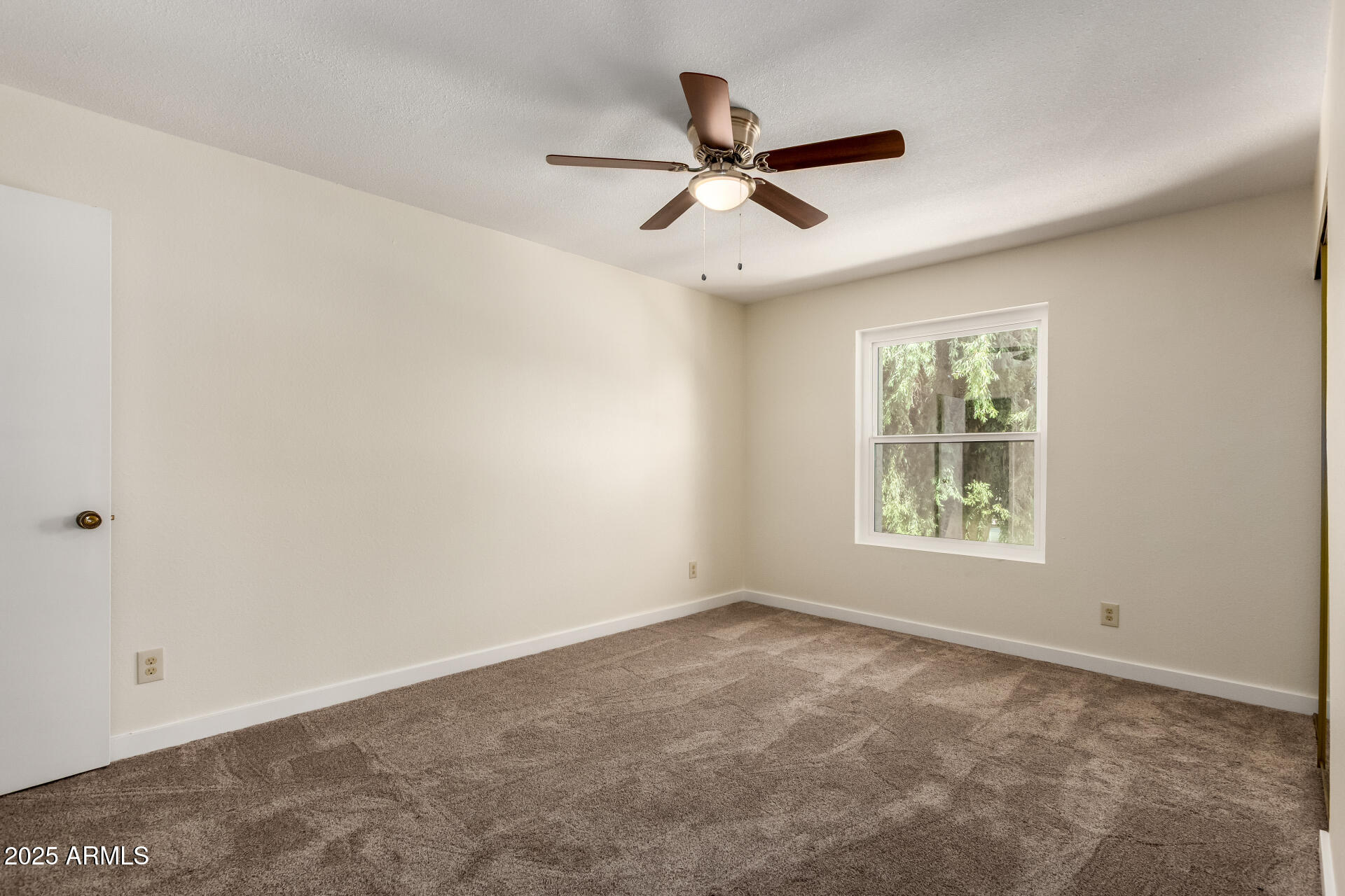 8635 South 48th Street, Unit 3 Phoenix, AZ 85044 - Photo 14 of 24 an empty room with a window and a fan