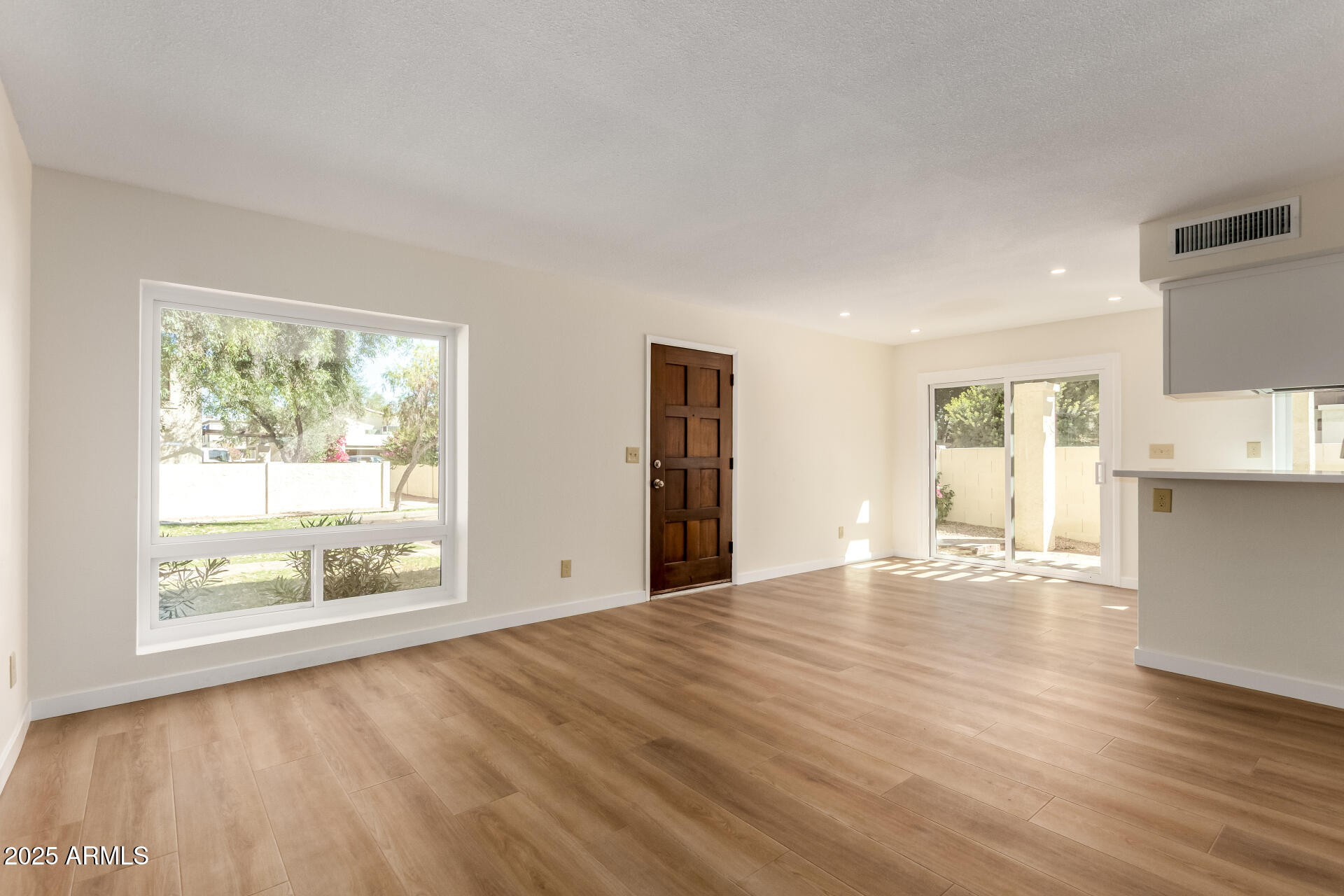 8635 South 48th Street, Unit 3 Phoenix, AZ 85044 - Photo 2 of 24 a view of an empty room with wooden floor and a window