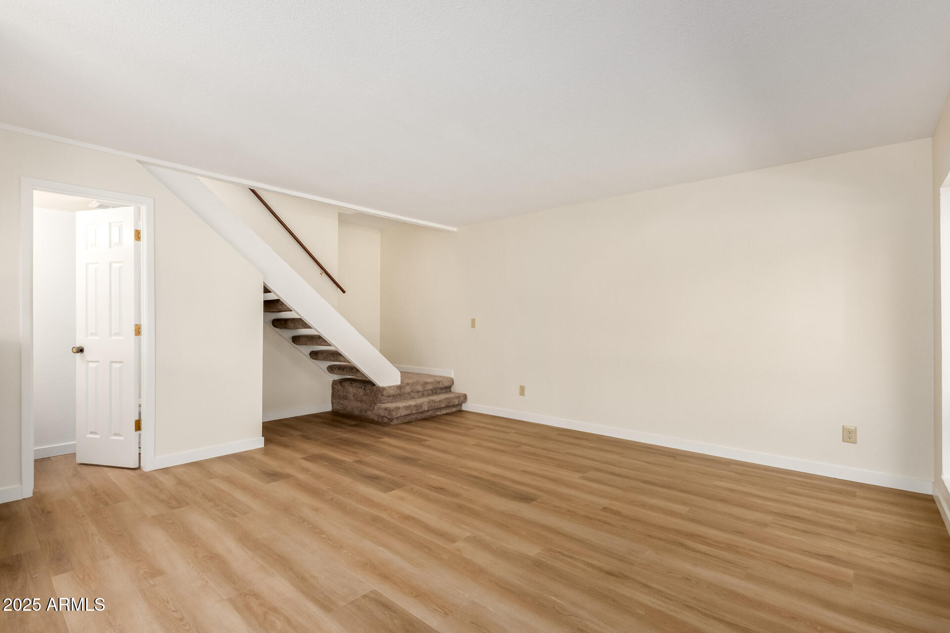 8635 South 48th Street, Unit 3 Phoenix, AZ 85044 - Photo 4 of 24 a view of an empty room with wooden floor and stairs