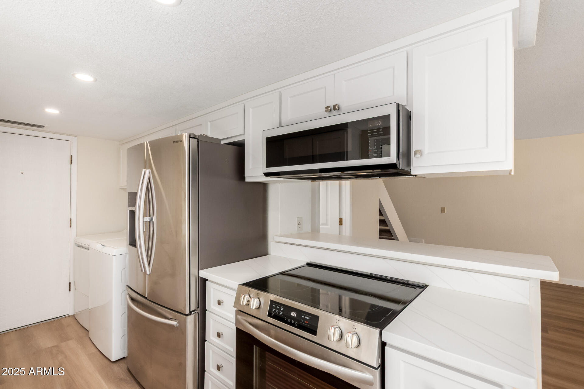 8635 South 48th Street, Unit 3 Phoenix, AZ 85044 - Photo 8 of 24 a kitchen with stainless steel appliances white cabinets and a refrigerator