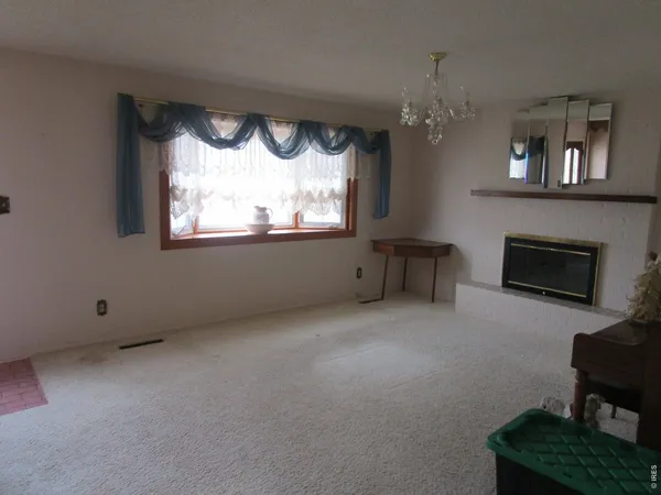an empty room with a fireplace and a large window