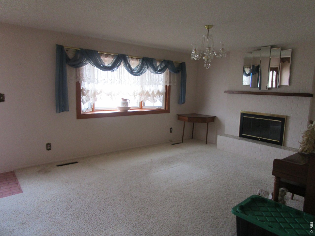 830 15th Street Burlington, CO 80807 - Photo 7 of 21 an empty room with a fireplace and a large window