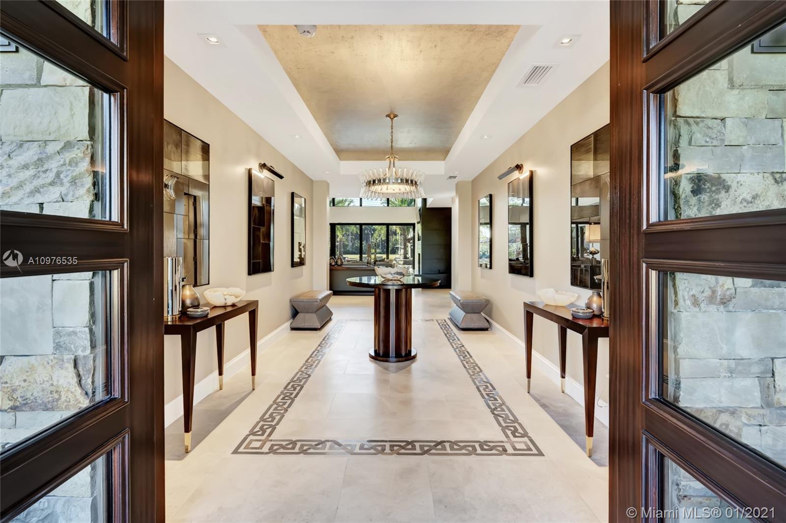 13900 Luray Road Southwest Ranches, FL 33330 - Photo 15 of 50 a hallway with dining area and chandelier