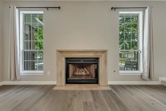 a kitchen with a sink dishwasher and white cabinets with wooden floor