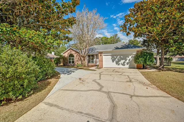 a front view of a house with a tree