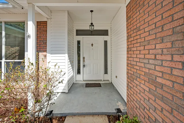 an empty room with wooden floor fireplace and windows