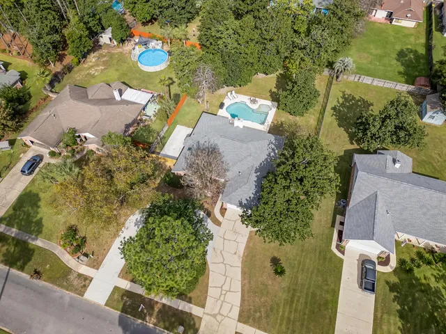 a view of an empty room with wooden floor and a ceiling fan
