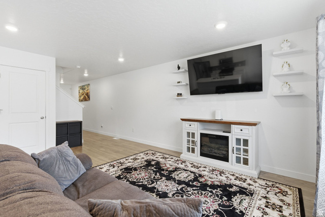 3808 Galatia Road Magna, UT 84044 - Photo 8 of 59 Bright living area featuring wood-finish flooring, recessed lighting, and a white decorative fireplace console with a wooden top