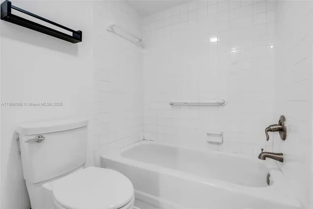 a white toilet sitting next to a bath tub