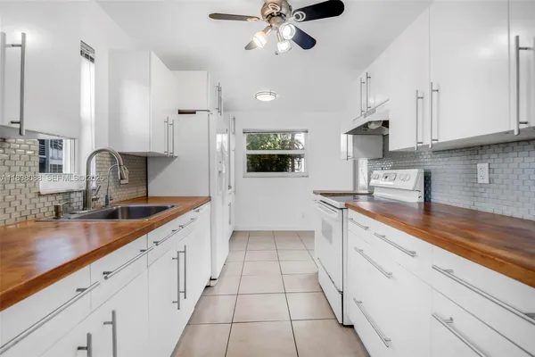 a kitchen with kitchen island granite countertop cabinets and white appliances
