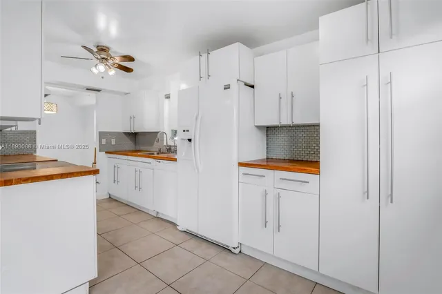 a kitchen with kitchen island granite countertop cabinets and white appliances