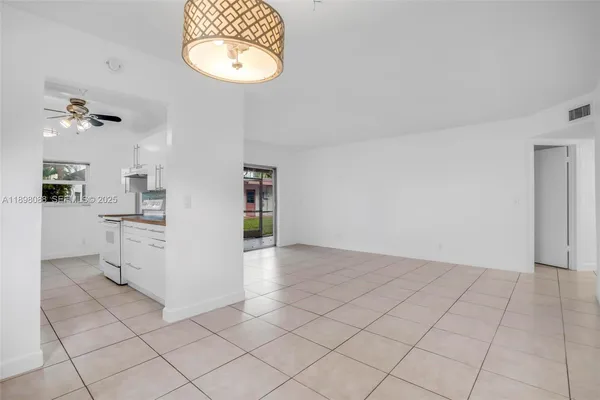 a view of a hallway with a shower and a chandelier fan