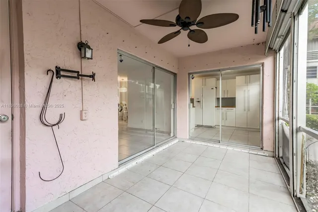 a view of a hallway with a shower and a chandelier fan