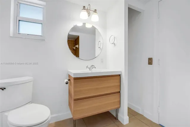 a bathroom with a toilet a sink and mirror