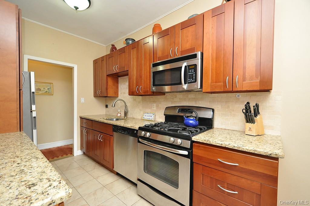 143 Garth Road, Unit 5J Scarsdale, NY 10583 - Photo 1 of 47 a kitchen with granite countertop a sink stove and microwave