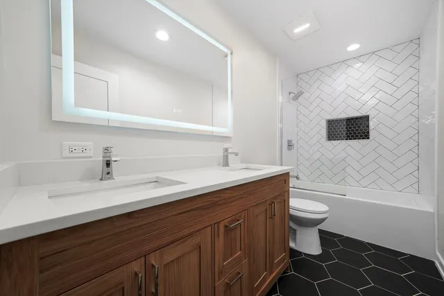 a bathroom with a double vanity sink mirror and toilet