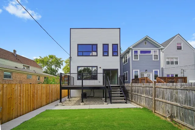 a view of a house with wooden deck and a big yard