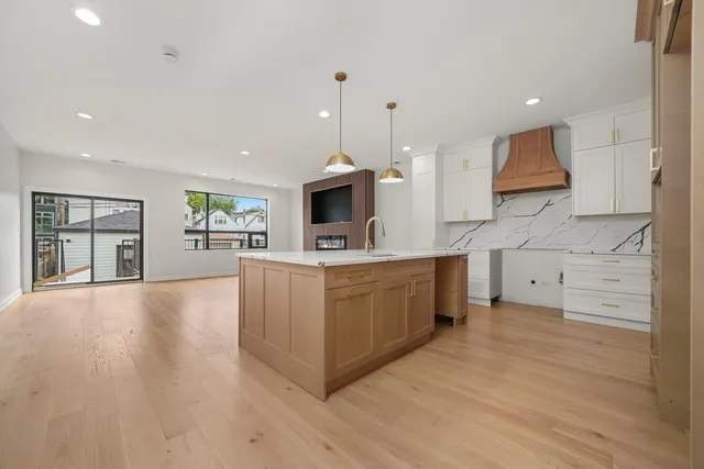 a kitchen with stainless steel appliances a stove top oven a sink a refrigerator white cabinets and a oven