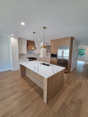 a kitchen with stainless steel appliances a stove top oven and sink