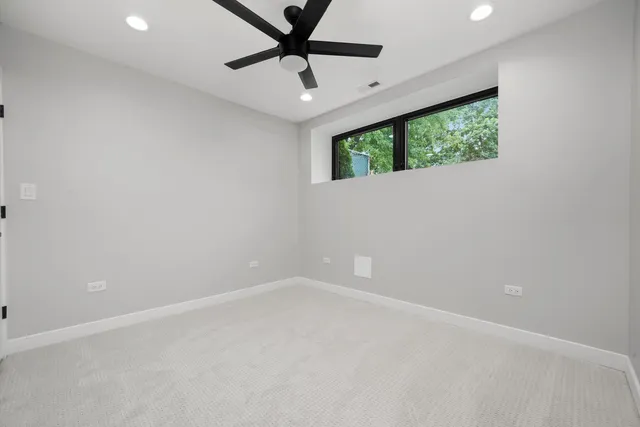 an empty room with a window and a fan