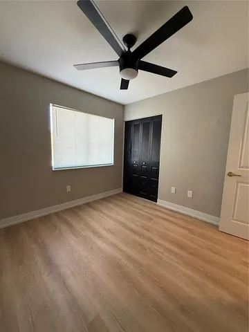 en empty room with windows and ceiling fan