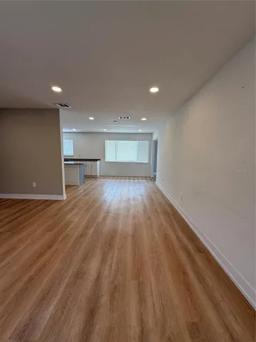 a view of empty room with wooden floor