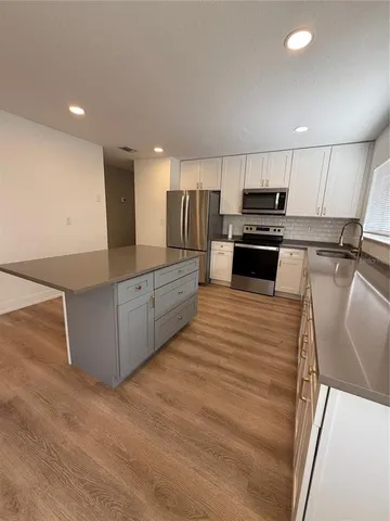 a kitchen with stainless steel appliances wooden cabinets a stove top oven a sink and dishwasher