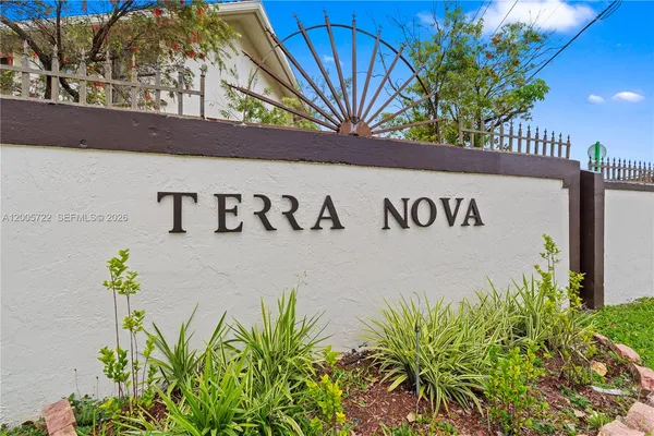 a sign that is on the wall with building in the background