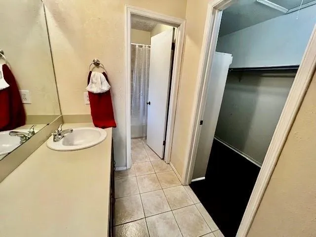 a bathroom with a sink and mirror with bathtub