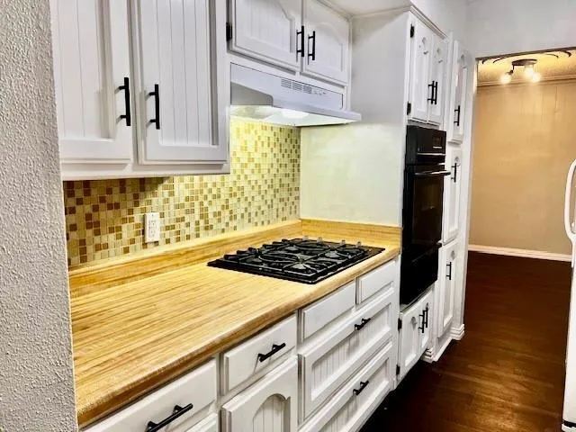 a kitchen with white cabinets and appliances