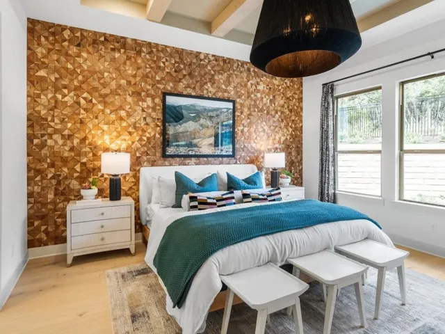 a bedroom with a bed and a painting on the wall