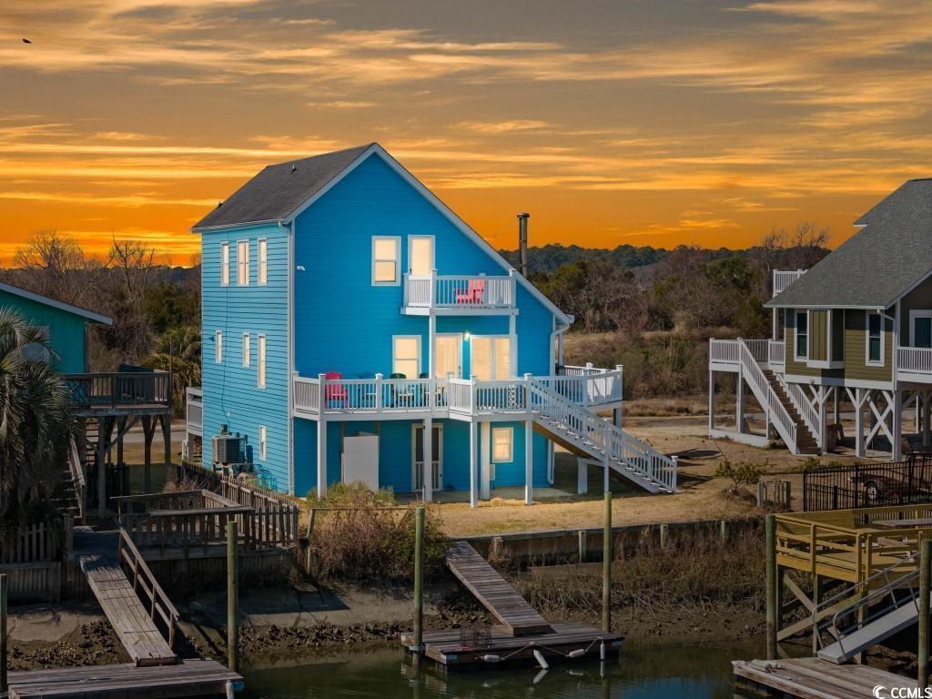 154 SandDollar Drive Holden Beach, NC 28462 - Photo 1 of 39 Back of house at dusk featuring stairway, a balcon