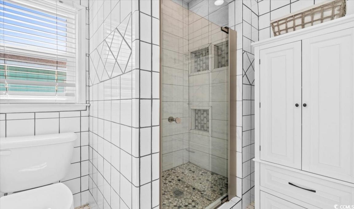 154 SandDollar Drive Holden Beach, NC 28462 - Photo 19 of 39 Bathroom featuring tile walls, a shower stall, and
