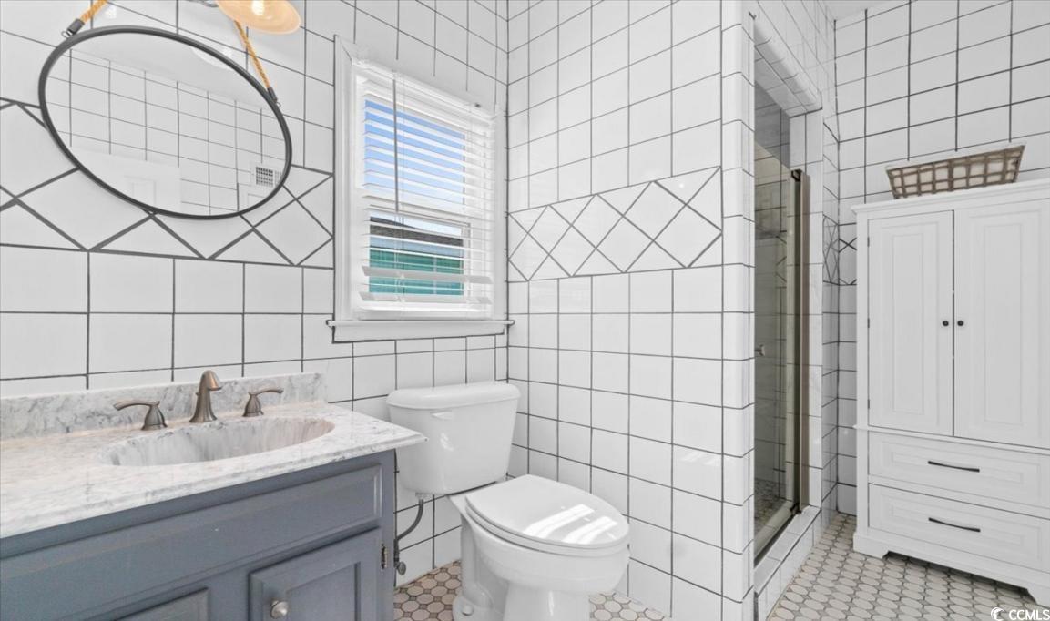 154 SandDollar Drive Holden Beach, NC 28462 - Photo 20 of 39 Bathroom with tile walls, vanity, a shower stall,