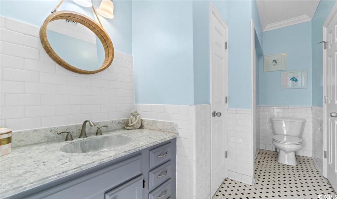 154 SandDollar Drive Holden Beach, NC 28462 - Photo 25 of 39 Bathroom featuring tile walls, crown molding, vani