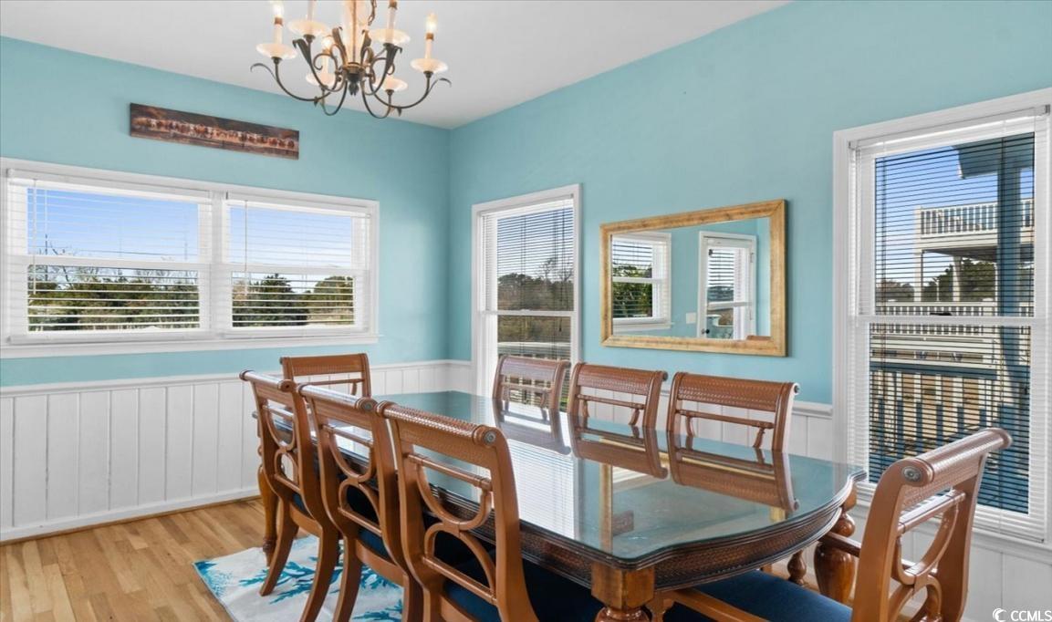 154 SandDollar Drive Holden Beach, NC 28462 - Photo 6 of 39 Dining space with a chandelier, wainscoting, and w
