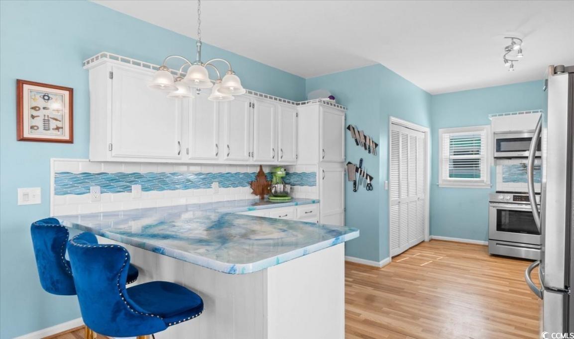 154 SandDollar Drive Holden Beach, NC 28462 - Photo 9 of 39 Kitchen with a peninsula, white cabinets, tasteful