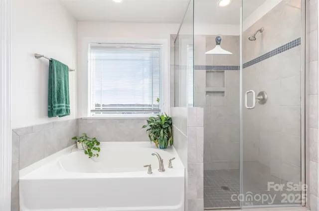 a spacious bedroom with a bed and a dresser with wooden floor