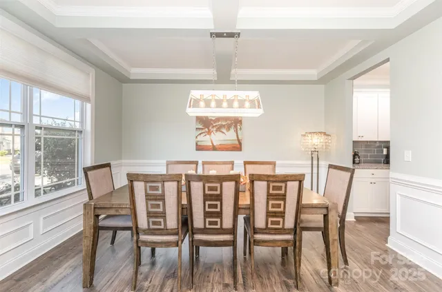 a view of a dining room with furniture wooden floor and chandelier