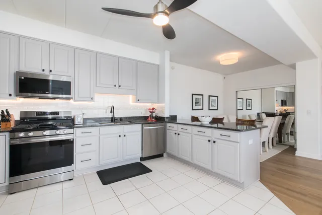 a kitchen with granite countertop appliances sink and cabinets