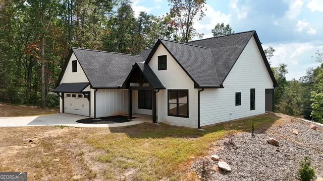 a view of a house with a yard and large tree