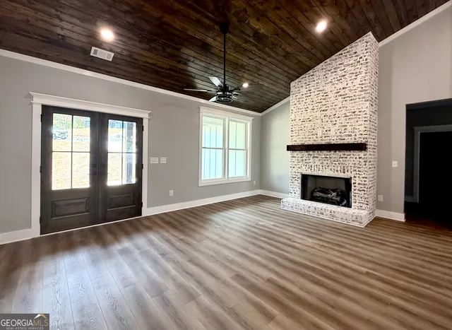 a view of empty room with wooden floor and fireplace