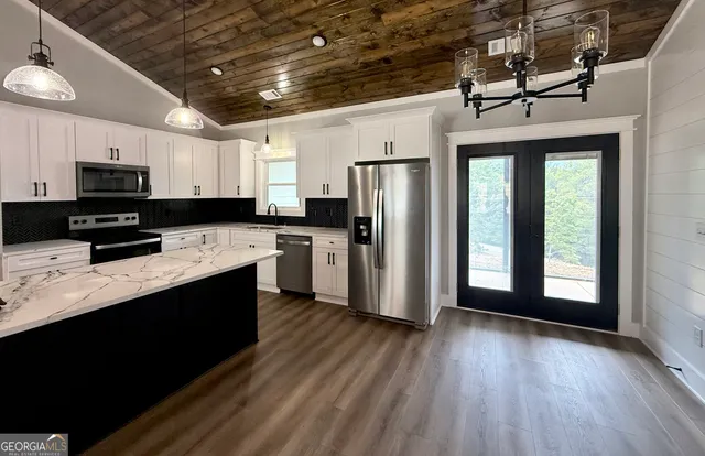 a kitchen with stainless steel appliances a refrigerator a sink a stove a microwave and cabinets